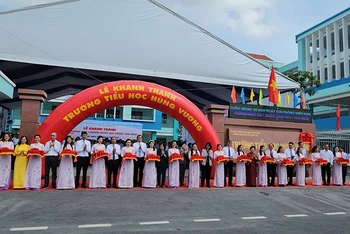 Các đại biểu thực hiện nghi thức cắt băng khánh thành Trường Tiểu học Hùng Vương. (Ảnh CTV).