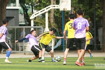 Một tình huống tranh chấp bóng trong trận đấu vòng bảng giữa đội Nhân Dân và Câu lạc bộ Đời sống xã hội.