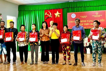 Đồng chí Trần Thị Thu Đông, Chủ tịch Hội Nhiếp ảnh Việt Nam, đại biểu Quốc hội và đại diện Tập đoàn Vingroup (giữa) trao quà Tết cho các hộ nghèo tại vùng ven biển thành phố Bạc Liêu.