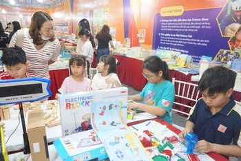 Các em học sinh trải nghiệm, sáng tạo tại gian hàng sách.
