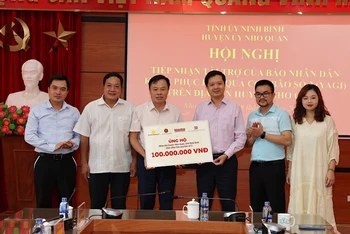 Đại diện Báo Nhân Dân và Công ty cổ phần Văn hóa học và học Việt Nam trao tặng tiền ủng hộ cho huyện Nho Quan (Ninh Bình).