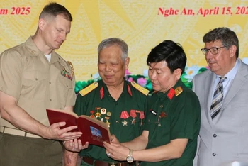 Cựu chiến binh Lê Đức Thuận (thứ 2, từ trái sang) xúc động khi nhận lại cuốn sổ ghi chép của mình.