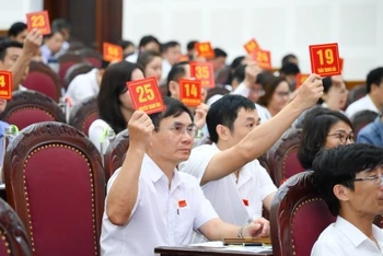 Các đại biểu biểu quyết thông qua Nghị quyết về việc tán thành chủ trương sắp xếp các đơn vị hành chính cấp xã trên địa bàn thành phố Vinh.