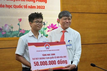 Ông Nguyễn Văn Hiếu, Giám đốc Sở Giáo dục và Đào tạo Thành phố Hồ Chí Minh trao thưởng cho em Nguyễn Việt Phong.