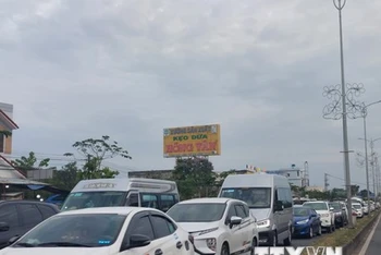 Xe ôtô nối đuôi nhau, nhích từng chút một qua cầu Rạch Miễu. (Ảnh: TTXVN)