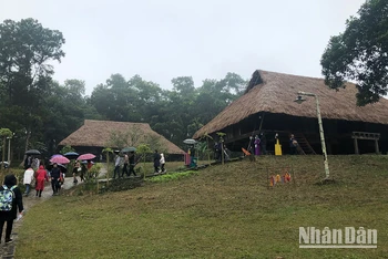 Du khách tham quan làng Mường tại Làng Văn hóa Du lịch các dân tộc Việt Nam.