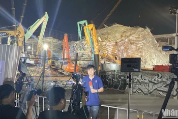 Phóng viên tác nghiệp tại hiện trường sập tòa nhà 30 tầng. (Ảnh: XUÂN SƠN)