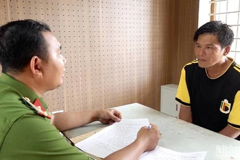 Công an bắt giữ Trần Minh Quân (bên phải) để điều tra về hành vi gây rối trật tự công cộng.