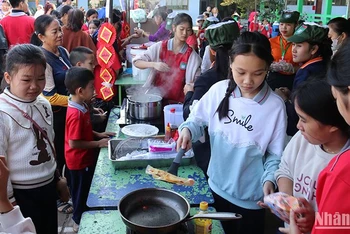 Các em học sinh hào hứng trải nghiệm và thưởng thức những món ăn truyền thống của Việt Nam tại hội chợ. (Ảnh: Hải Tiến)