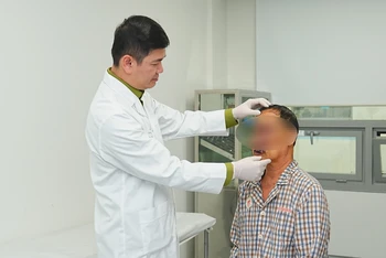 Bác sĩ thăm khám lại cho bệnh nhân sau phẫu thuật.