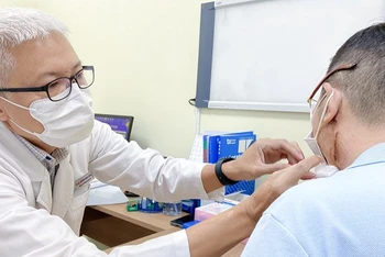 Bác sĩ Đoàn Minh Trông kiểm tra vết mổ u tuyến mang tai cho ông C.