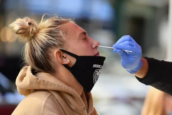 Nhân viên y tế lấy mẫu xét nghiệm Covid-19 cho người dân tại New York, Mỹ. (Ảnh: AFP/TTXVN)