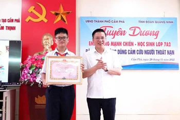 Ủy viên Ban Thường vụ Thành ủy, Phó Chủ tịch Thường trực UBND TP Cẩm Phả Đinh Ngọc Chiến trao khen thưởng cho em Hoàng Mạnh Chiến. (Nguồn: campha.gov.vn)