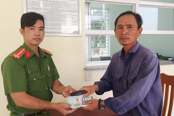 Công an phường 6, thành phố Cao Lãnh, tỉnh Đồng Tháp tiếp nhận chiếc ví bên trong có gần 25 triệu đồng do anh Nguyễn Thành Duyên trao trả.
