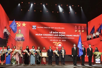 Thừa ủy quyền của Chủ tịch nước, Bộ trưởng Giáo dục và Đào tạo Nguyễn Kim Sơn trao Huân chương Lao động hạng Nhất cho Trường THCS và THPT Nguyễn Siêu. (Ảnh: THẾ ĐẠI)