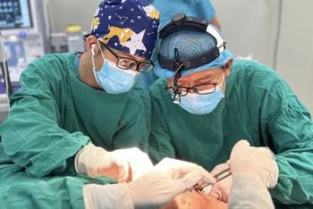 Các bác sĩ đang thực hiện ca phẫu thuật tạo hình vết thương phần mềm má.