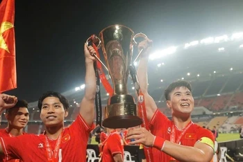 Duy Mạnh và Văn Thanh hân hoan giương cao cup vô địch. (Ảnh: Minh Quyết/TTXVN)