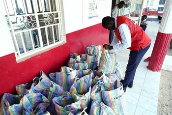 Nhân viên Chữ thập đỏ Gambia kiểm tra số siro ho thu giữ tại Banjul, ngày 6/10/2022. (Ảnh: AFP/TTXVN)