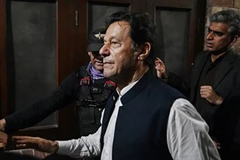 Cựu Thủ tướng Pakistan Imran Khan (phía trước) rời khỏi toà án ở Lahore, ngày 17/3/2023. (Ảnh: AFP/TTXVN)