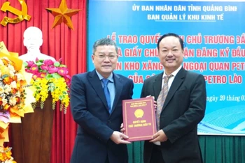 Phó Chủ tịch tỉnh Quảng Bình Phan Phong Phú (bên trái) trao quyết định chủ trương đầu tư dự án cho lãnh đạo Công ty trách nhiệm hữu hạn Petro Lào.