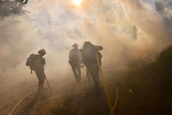 Lính cứu hỏa làm việc tại hiện trường vụ cháy Post Fire ở Gorman, cách Los Angeles, khoảng 100 km về phía bắc. (Ảnh: Tân Hoa xã)