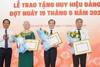 Chủ tịch Ủy ban nhân dân Thành phố Hồ Chí Minh Nguyễn Văn Được trao Huy hiệu 45 năm tuổi đảng cho các đảng viên. (Ảnh: LÊ VĨNH)