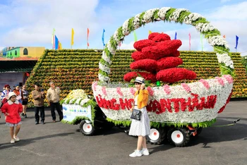 Du khách lưu dấu kỷ niệm bên xe hoa của Làng hoa Vạn Thành tham gia Festival Hoa Đà Lạt năm 2022.