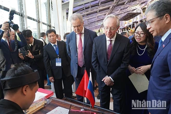Đại sứ Đặng Minh Khôi cùng Thứ trưởng Ngoại giao Nga Mikhail Galuzin, Chủ nhiệm Ủy ban Đối ngoại thành phố Saint Petersburg Evgeny Grigoriev xem viết thư pháp tại Lễ kỷ niệm 78 năm Quốc khánh Việt Nam tại Liên bang Nga. (Ảnh: XUÂN HƯNG)