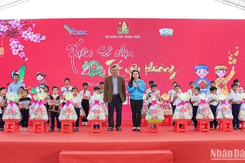 Bí thư Trung ương Đoàn, Chủ tịch Hội đồng Đội Trung ương Nguyễn Phạm Duy Trang (áo xanh) cùng đại diện các đơn vị liên quan trao quà Tết tặng thiếu nhi có hoàn cảnh khó khăn tại ngày hội.