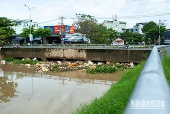 Lúc 8 giờ 30 sáng 8/11, miệng cống cầu Đa Cô càng lúc bị chẹt cứng do rác thải sinh hoạt và lục bình dồn về. Anh Hoàng Khánh Nam (ngụ đường Đồng Trí) cho biết, rác đã dồn lại ở miệng cống từ tờ mờ sáng nay, đến giờ thì lượng rác một lúc một nhiều.