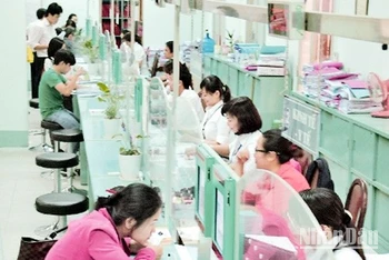 Người dân làm thủ tục tại phòng tiếp nhận và trả kết quả của UBND quận 1, TP Hồ Chí Minh.