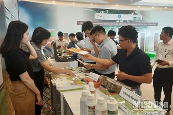Các đại biểu tham quan gian hàng trưng bày các sản phẩm nông nghiệp sạch tại hội nghị.