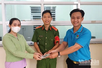 Công an phường 6 và anh Nguyễn Minh Toàn bàn giao lại chiếc ví cho chị Lê Thị Huỳnh Oanh.