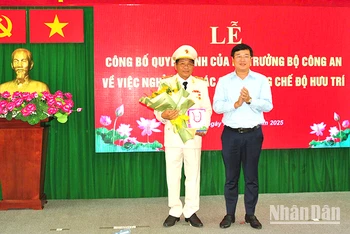 Ủy viên Trung ương Đảng, Bí thư Tỉnh ủy Đồng Tháp Lê Quốc Phong trao Huy hiệu 40 năm tuổi Đảng và tặng hoa chúc mừng Đại tá Nguyễn Văn Hiểu. (Ảnh: Công an cung cấp)