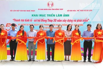 Nghi thức cắt băng khai mạc triển lãm ảnh. (Ảnh: NHƯ ANH)
