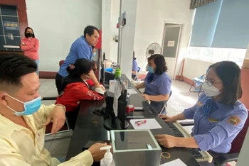 Nhân viên ga Sài Gòn bán vé tàu Tết Quý Mão cho hành khách tại nhà ga.