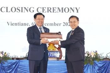 Chủ tịch Quốc hội Vương Đình Huệ nhận búa đảm nhận chức Chủ tịch Hội nghị cấp cao Quốc hội ba nước CLV lần thứ hai từ Chủ tịch Quốc hội nước Lào Saysomphone Phomvihane. (Ảnh: TTXVN)
