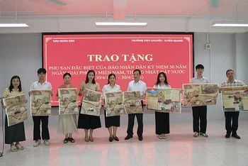 Trưởng Văn phòng đại diện Báo Nhân Dân tại Tuyên Quang trao tặng phụ san đặc biệt cho thầy, cô giáo và các em học sinh trường THPT Chuyên Tuyên Quang.