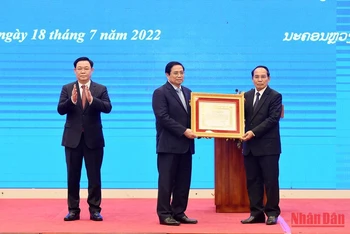 Đồng chí Bounthong Chitmany, Ủy viên Bộ Chính trị, Thường trực Ban Bí thư, Phó Chủ tịch nước Lào trao Huân chương Vàng quốc gia của Lào cho đồng chí Phạm Minh Chính, Ủy viên Bộ Chính trị, Thủ tướng Chính phủ.