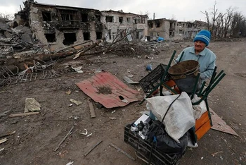 Người phụ nữ đẩy xe chở đồ đạc dọc theo một tuyến đường tại vùng Donetsk, Ukraine, ngày 15/3. (Ảnh: Reuters)
