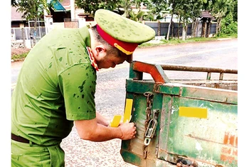 Công an thị xã Buôn Hồ dán decal cho xe công nông của người dân.