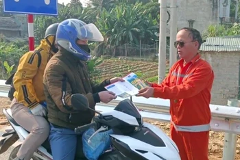 Cán bộ Công ty cổ phần Quản lý và Đầu tư xây dựng công trình giao thông 238 tuyên truyền, nhắc nhở người dân đi xe máy không đi vào tuyến đường cao tốc.