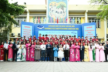 Hai Phu nhân chụp ảnh lưu niệm tại sân trường cùng Ban Giám hiệu và các em học sinh Trường phổ thông cơ sở Nguyễn Đình Chiểu.