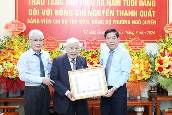 Đồng chí Nguyễn Thanh Quất (đứng giữa) nhận Huy hiệu 80 năm tuổi đảng.