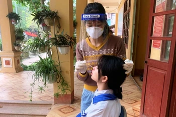 Lấy mẫu xét nghiệm cúm A trên học sinh ở thị trấn Phố Ràng, huyện Bảo Yên, tỉnh Lào Cai. (Ảnh TL)