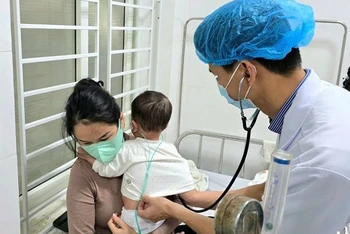Bác sĩ Khoa Bệnh Nhiệt đới (Bệnh viện Sản-Nhi Nghệ An) khám cho bệnh nhi mắc sởi.