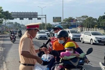 Lực lượng Cảnh sát giao thông phát nước giúp người tham giao thông trên đường về quê đón Tết Nguyên đán 2023.