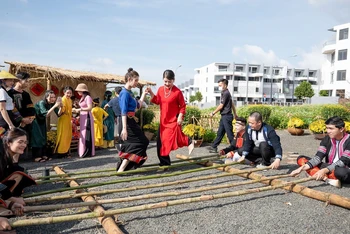 Du khách trải nghiệm múa sạp tại "Phiên chợ xưa" trong hành trình trải nghiệm và khám phá Thành phố Cà-phê ở Bảo tàng Thế giới Cà-phê dịp Tết Nguyên đán 2023 tại Đắk Lắk. (Ảnh: Công Lý)