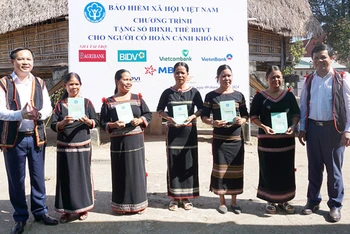 Phó Tổng Giám đốc Bảo hiểm xã hội Việt Nam Chu Mạnh Sinh trao sổ bảo hiểm xã hội, thẻ bảo hiểm y tế tặng người dân xã Đăk La, huyện Đăk Hà, Kon Tum. (Ảnh: KSS)