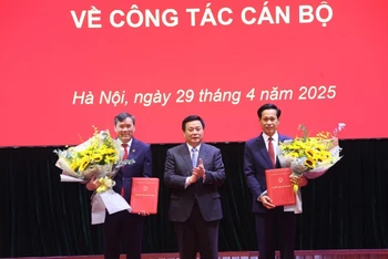Đồng chí Nguyễn Xuân Thắng, Ủy viên Bộ Chính trị, Giám đốc Học viện Chính trị quốc gia Hồ Chí Minh, Chủ tịch Hội đồng Lý luận Trung ương trao quyết định của Ban Bí thư cho các đồng chí Phó Giám đốc Học viện Chính trị quốc gia Hồ Chí Minh Hoàng Phúc Lâm và Lê Văn Lợi.
